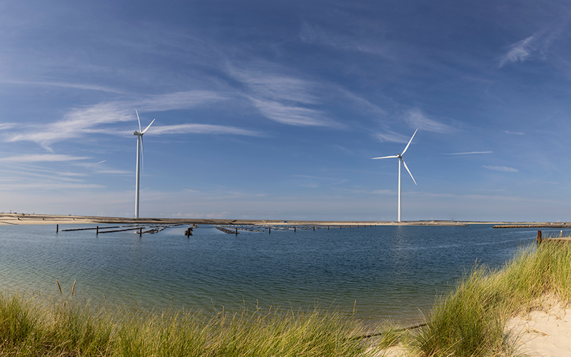 Abbildung moderner Windkraftanlagen in einer Küstenlandschaft