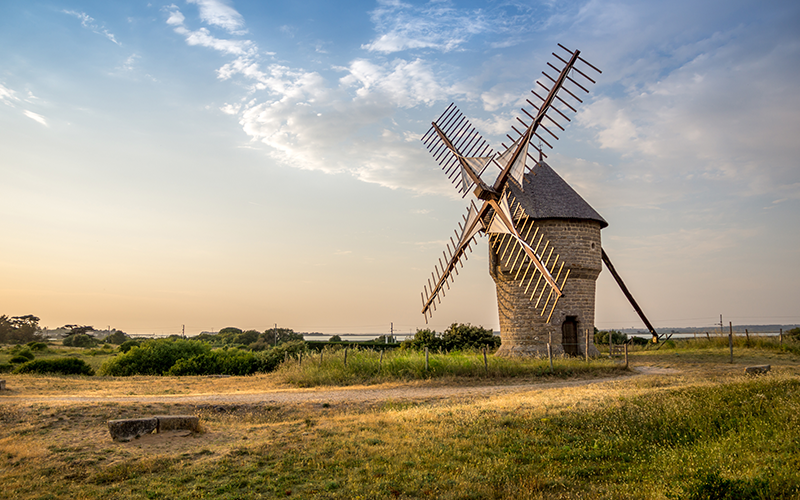 Abbildung einer historischen Windmühle in einer ländlichen Landschaft
