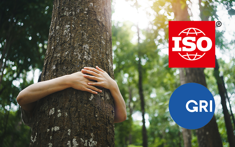 Person umarmt einen Baum im Wald. Rechts im Bild sind Logos von zwei Siegeln zu sehen, ISO und GRI