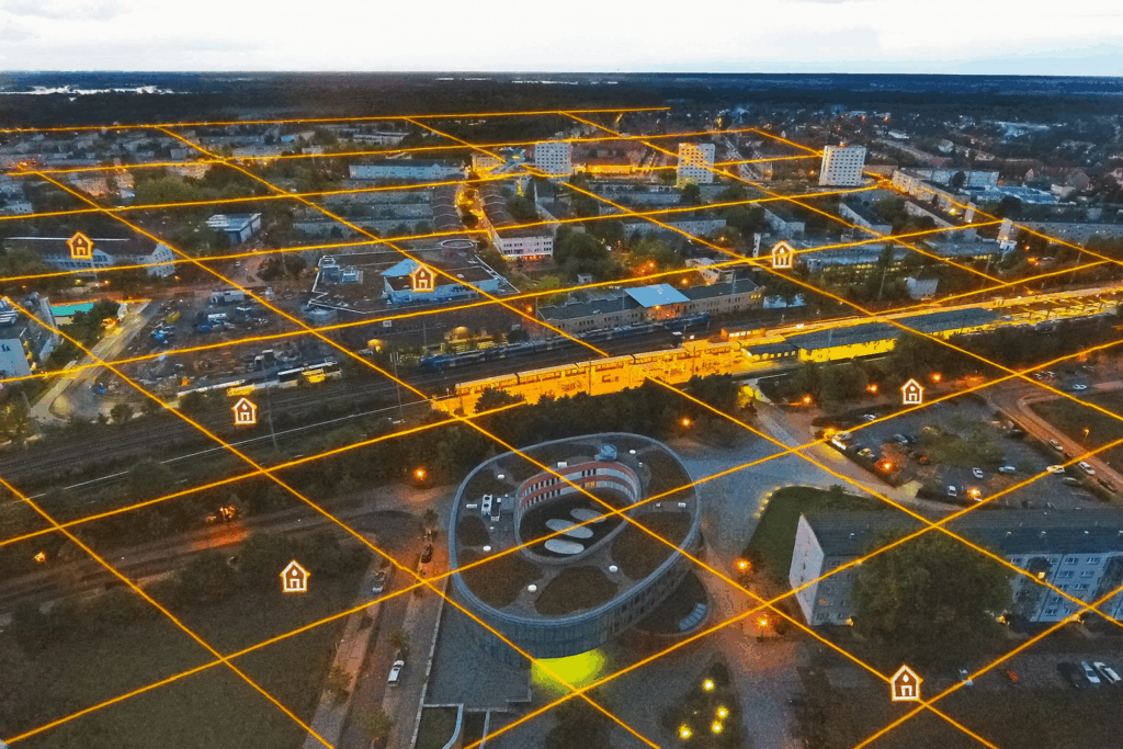 Luftaufnahme von Hennigsdorf mit leuchtend orangefarbenem Versorgungsraster und Haussymbolen, die das lokale Wärmenetz darstellen (Beispiel).
