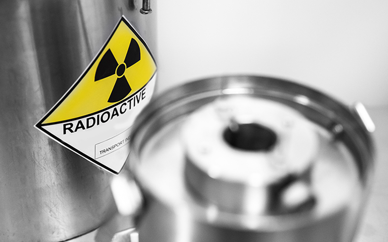 Behälter mit Aufkleber „Radioaktives Material“