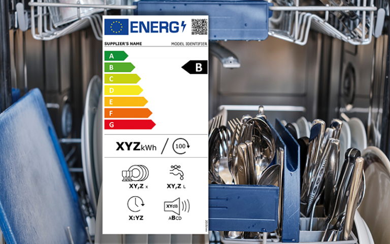 Energieeffizienzlabel mit Bewertung B vor geöffnetem Geschirrspüler gefüllt mit Besteck und Geschirr.