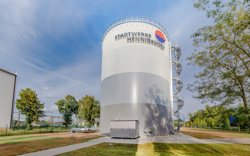 Runder, hoher Multifunktionsspeicher mit außenliegender Wendeltreppe und Schriftzug „Stadtwerke Hennigsdorf" auf der Oberseite.