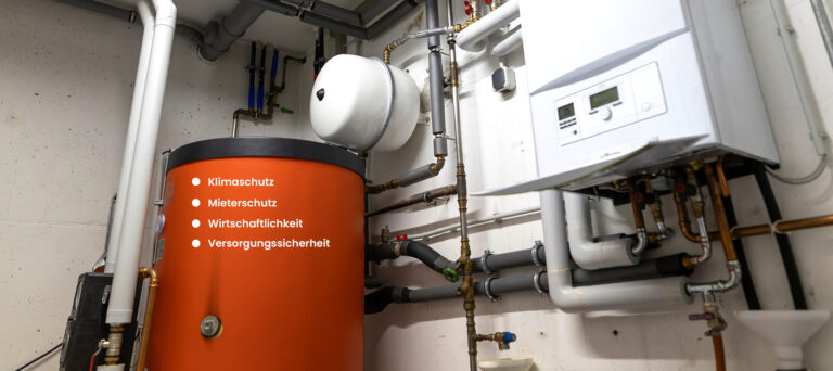 Heizungsanlage mit Warmwasserspeicher und Gastherme. Eingeblendete Begriffe: Klimaschutz, Mieterschutz, Wirtschaftlichkeit und Versorgungssicherheit.