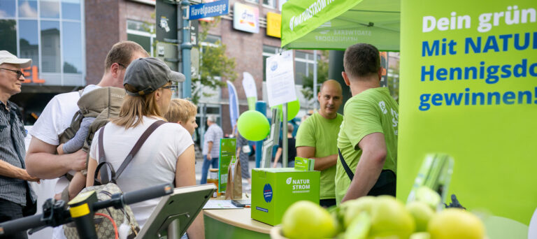 Menschen informieren sich an einem NATURSTROM-Stand der Stadtwerke Hennigsdorf auf der Hennigsdorfer Festmeile in 2025